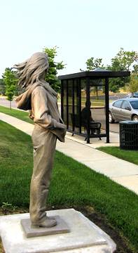 [Statue of woman at a bus stop]