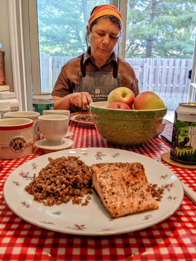 A plate with red rice and a cooked filet of fjord trout.