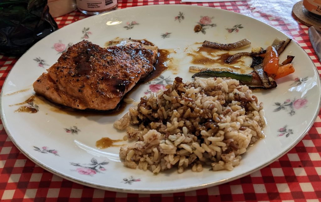 Fjord trout, rice, and mixed onions and peppers on a plate