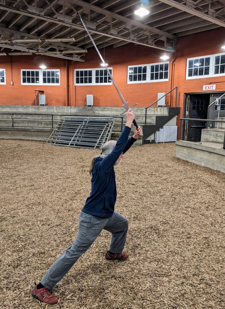 Standing in a ready stance with my longsword raised and pointing up