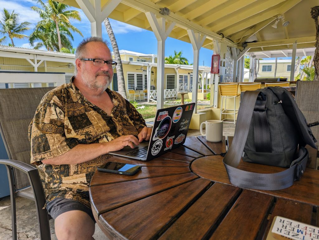 Steven D. Brewer sitting at the table under the tamarind tree at Cottages by the Sea on St. Croix