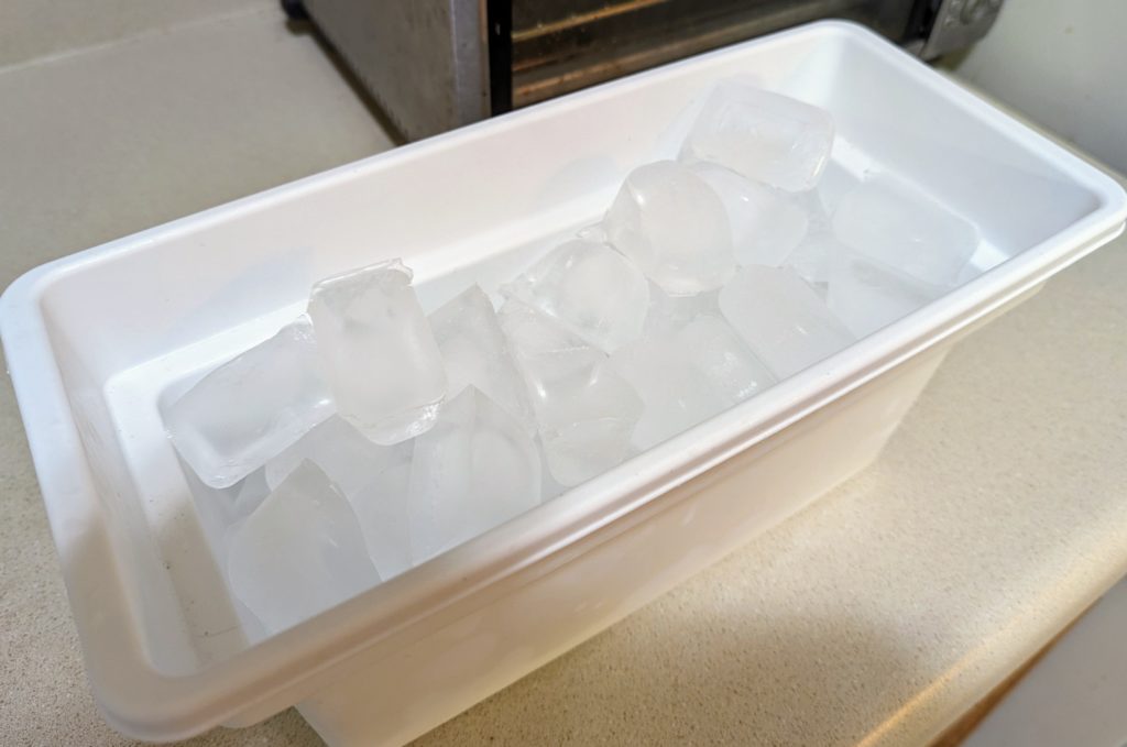 A ice bucket, freshly filled on the counter