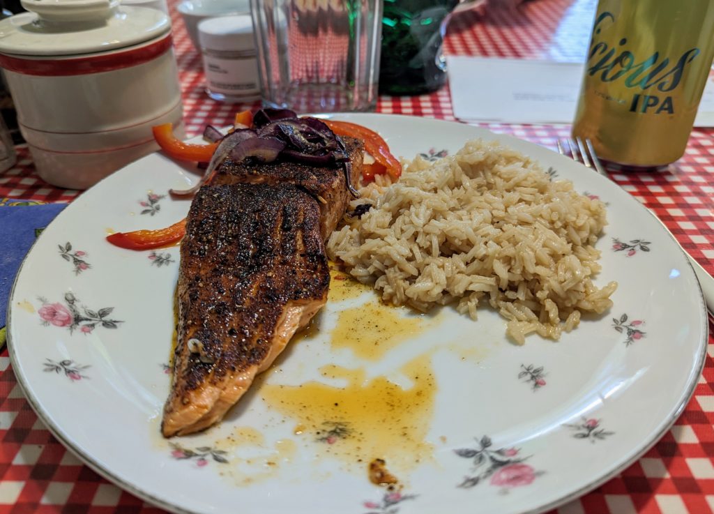 Fjord trout on a plate with rice and red onion and red pepper