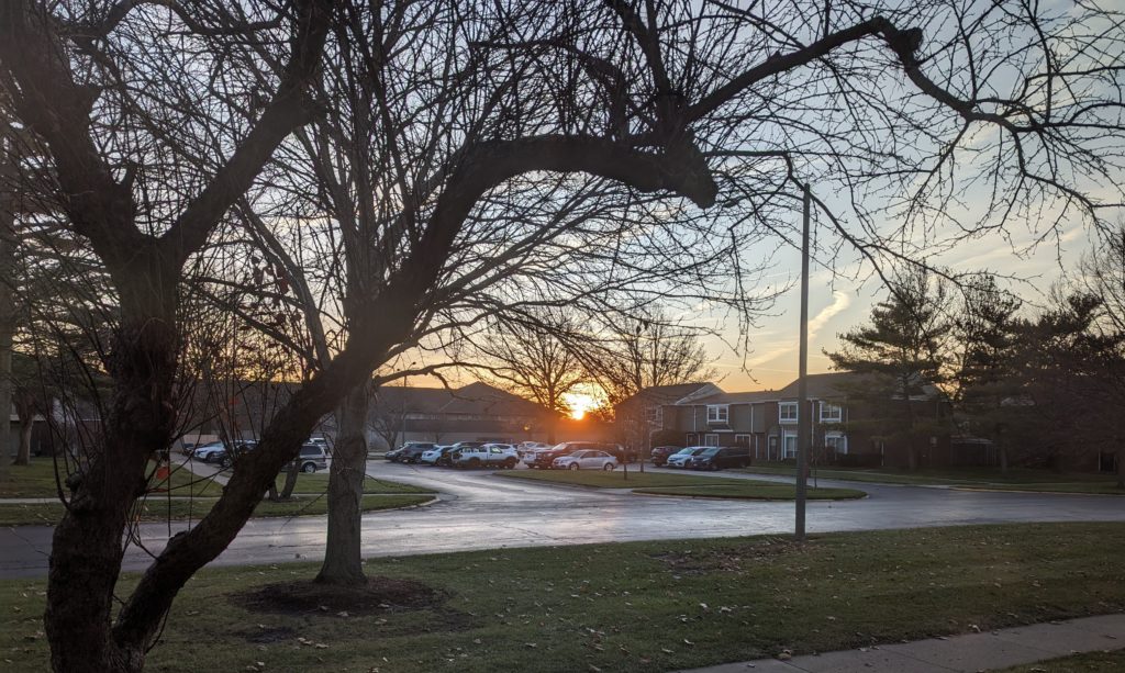 Sun rise visible between two buildings