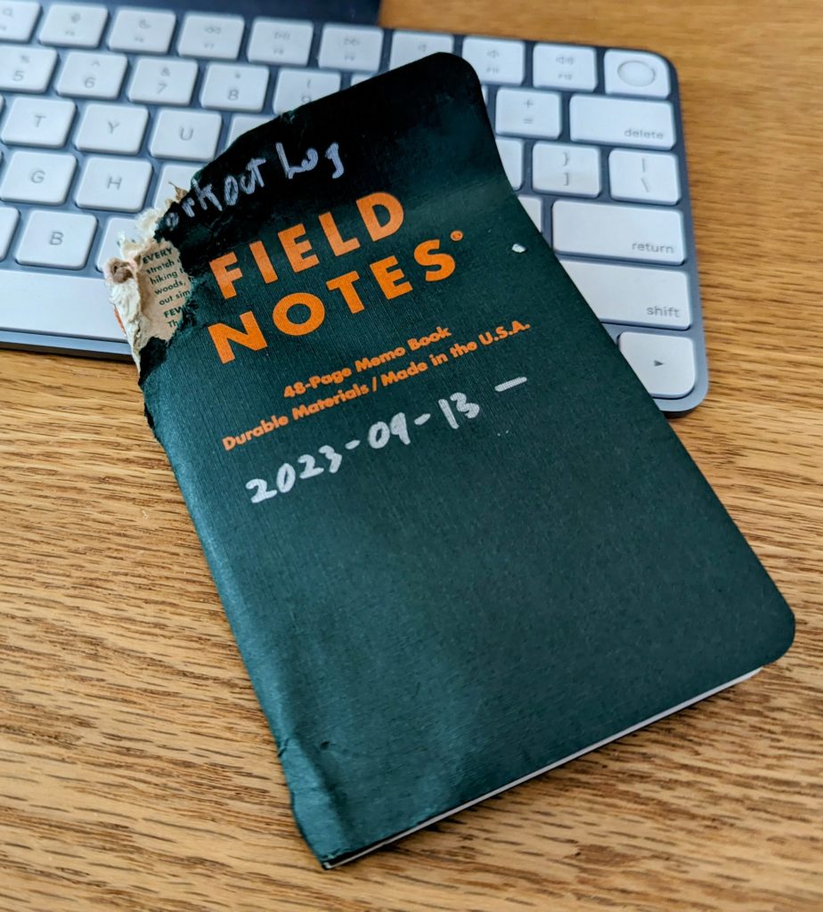 A Field Notes notebook with a top corner chewed off by the dog