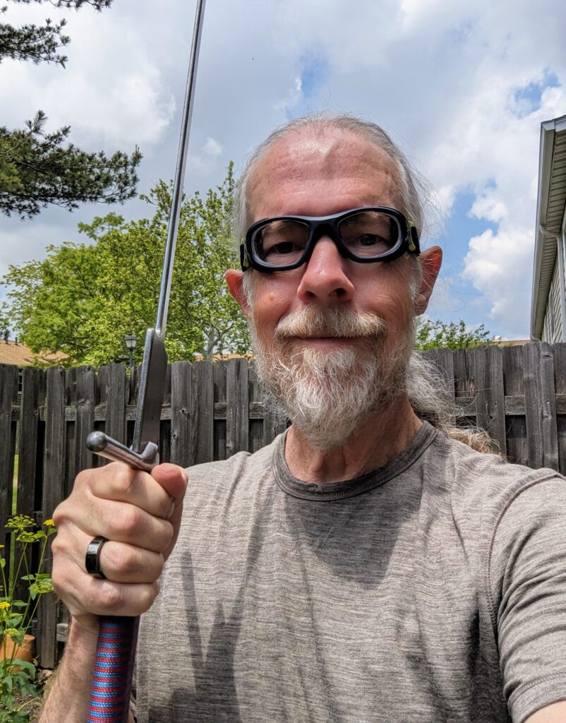 Me wearing my new fencing goggles and holding a sword