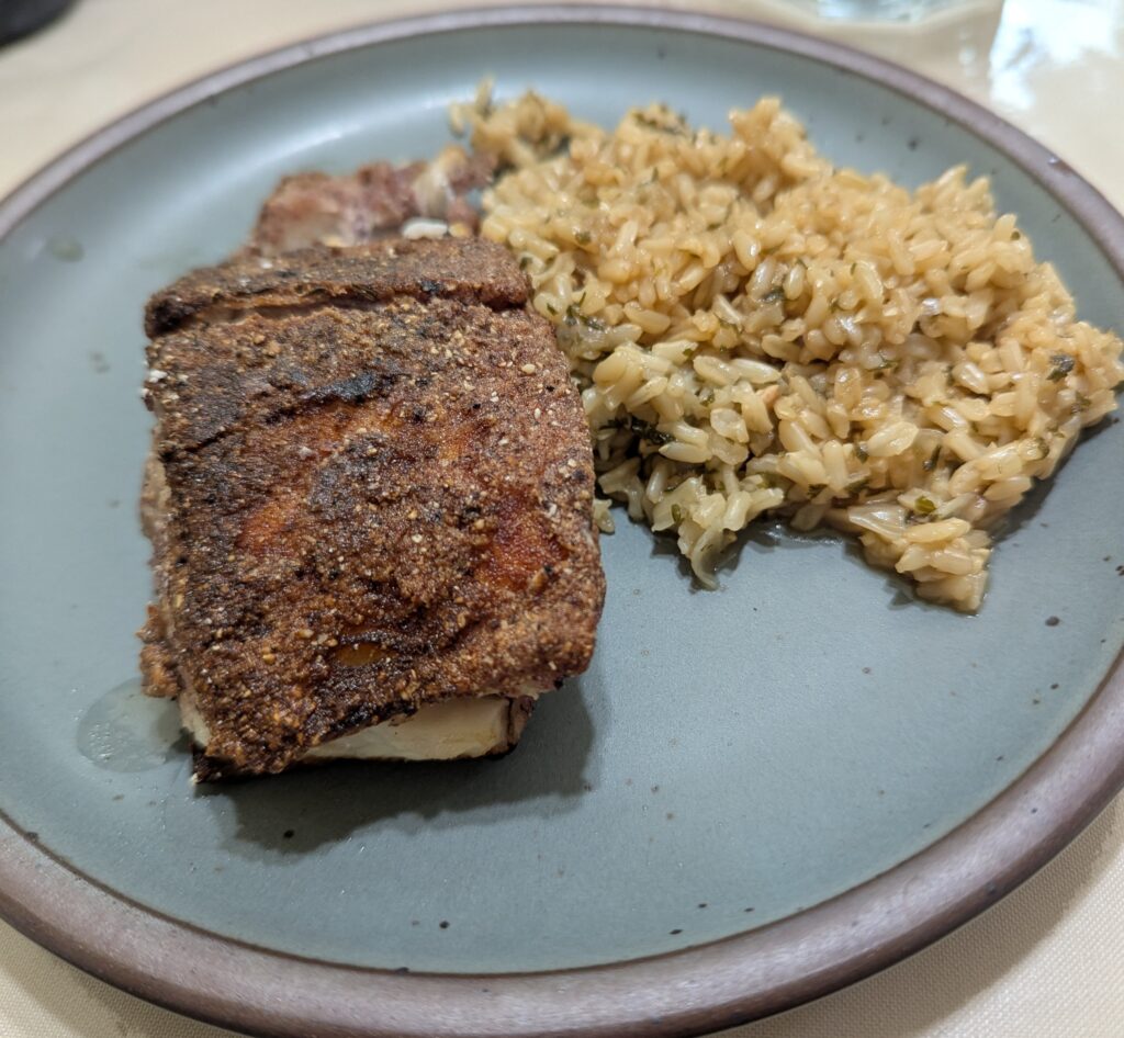 A plate with battered fish and brown rice