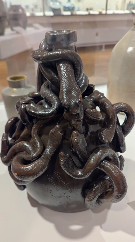 a jug sculpted to have numerous snakes crawling over it